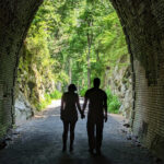 A couple holding hands while walking through the Blue Ridge Tunnel West Portal – Waynesboro, VA. Photo by Nancy Sorrells.