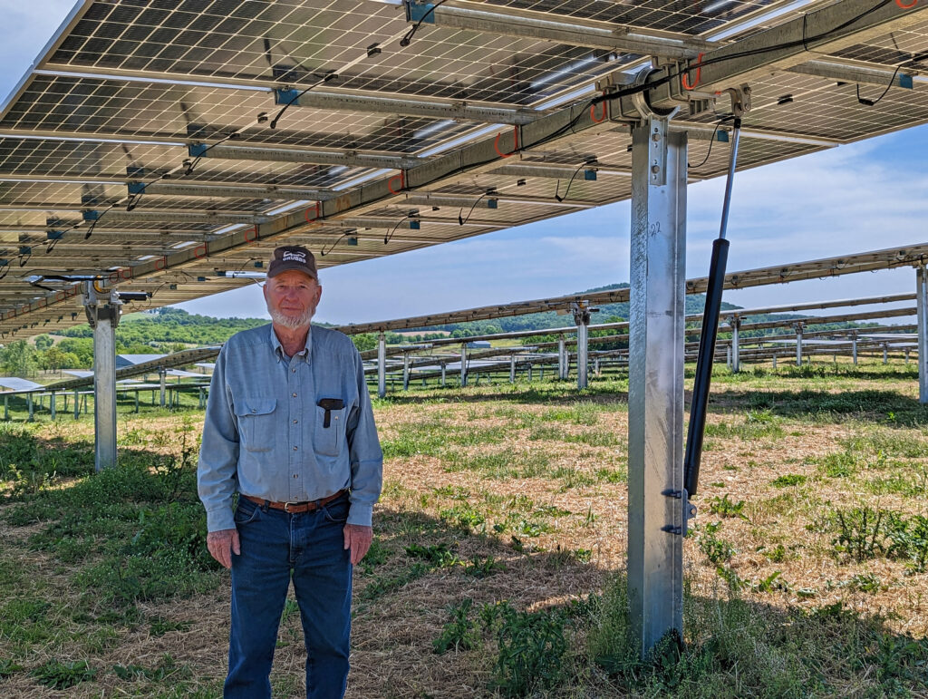 Sorrells, Harvesting the Sun, Fred Garber under Shenandoah Valley Electric Coop solar array, Mt. Jackson, Shenandoah Co – Nancy Sorrells Man under Shenandoah Valley Electric Coop solar array